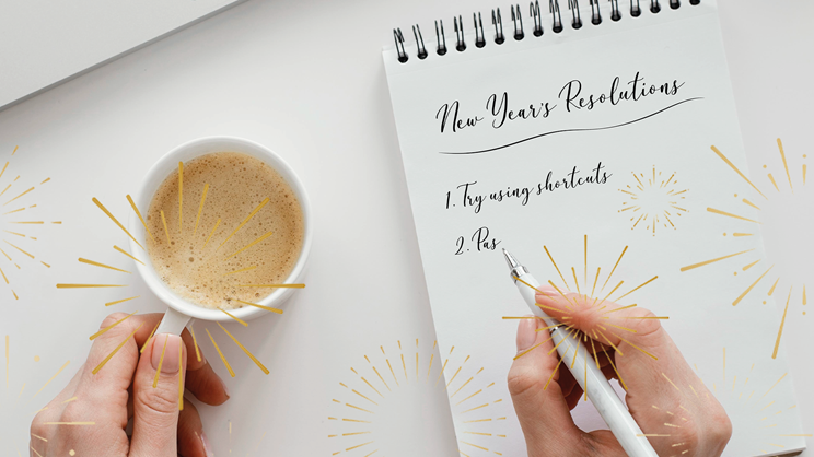 A person holds a cup of coffee in one hand and writes “New Year’s Resolutions: 1. Try using shortcuts, 2. Pas” on a notepad with the other, surrounded by sparkling gold fireworks graphics for festive New Year’s resolutions inspiration.