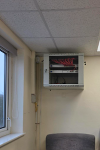 The same corner after installation - a neatly racked and cabled network cabinet mounted on the wall